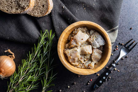 Chopped marinated fish. Salted herring in bowl on black table. Top view.