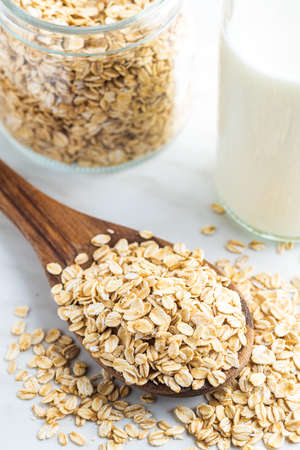 Breakfast cereals. Uncooked oatmeal. Raw oat flakes in wooden spoon.