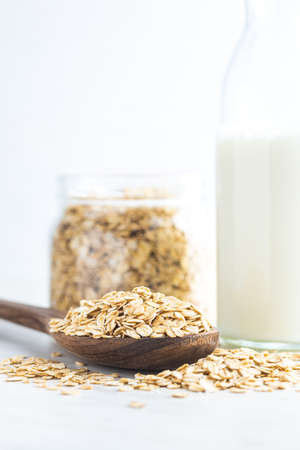 Breakfast cereals. Uncooked oatmeal. Raw oat flakes in wooden spoon.