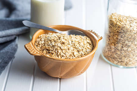 Breakfast cereals. Uncooked oatmeal. Raw oat flakes in bowl.