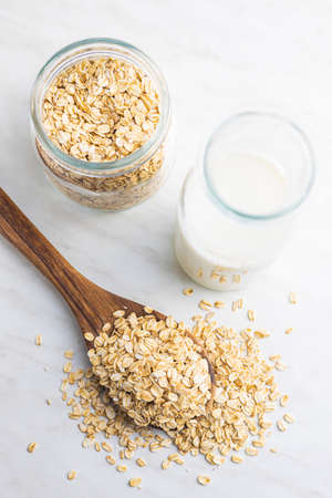 Breakfast cereals. Uncooked oatmeal. Raw oat flakes in wooden spoon. Top view.の写真素材