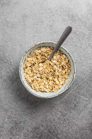 Breakfast cereals. Uncooked oatmeal. Raw oat flakes in bowl. Top view.の写真素材