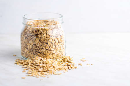 Breakfast cereals. Uncooked oatmeal. Raw oat flakes in jar.の写真素材