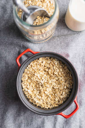 Breakfast cereals. Uncooked oatmeal. Raw oat flakes in pot. Top view.の写真素材