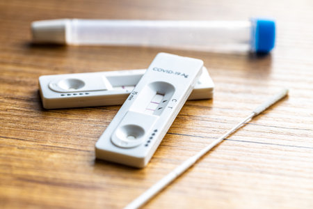 Positive Covid-19 antigen test. Coronavirus antigen rapid test on wooden table.