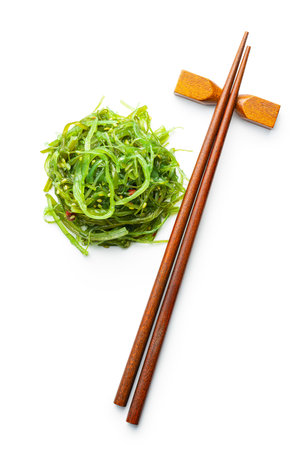 Green wakame. Seaweed salad and chopsticks isolated on a white background.の写真素材