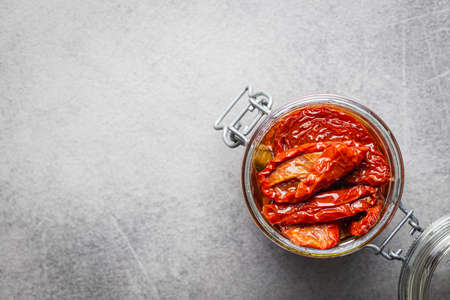 Sun dried tomato. Pickled tomatoes in jar on kitchen table. Top view.