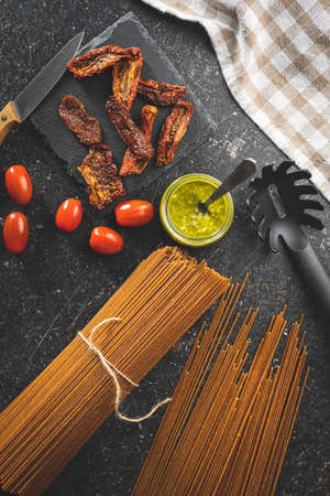 Uncooked whole grain spaghetti. Raw pasta on a kitchen table. Top view.の写真素材