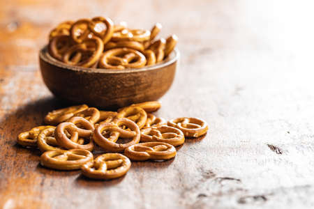 Mini pretzels. Crusty salted snack on a wooden table.の写真素材