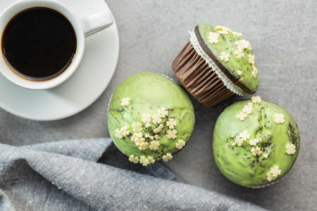 Sweet muffins with pistachio icing. Sweet dessert on a kitchen table. Top view.の写真素材