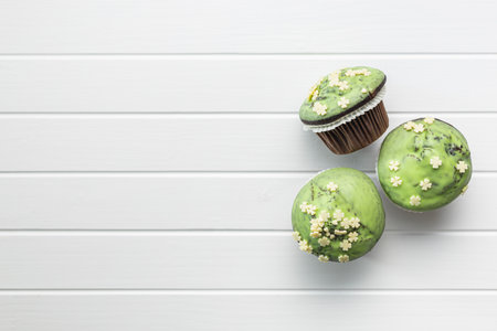 Sweet muffins with pistachio icing. Sweet dessert on a kitchen table. Top view.