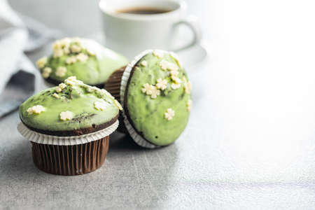 Sweet muffins with pistachio icing. Sweet dessert on a kitchen table.の写真素材