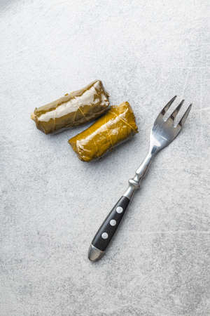Dolmades. Stuffed vine leaves. Greek appetizer with the fork. Top view.の写真素材