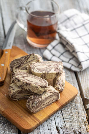 Sweet tahini halva with cocoa flavor. Turkish dessert on a cutting board.