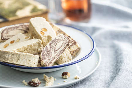 Sweet tahini halva with cocoa flavor and almonds. Turkish dessert on a plate.の写真素材