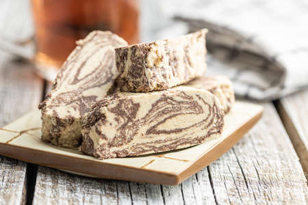 Sweet tahini halva with cocoa flavor. Turkish dessert on a plate.
