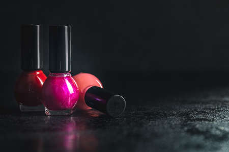 Colorful nail polish bottles on a black table.