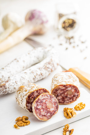 Traditional sausage with white mold. Dried sliced pork salami on a cutting board.の写真素材