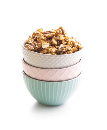 Peeled walnut kernels in bowl isolated on a white background.