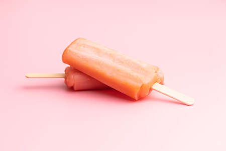Fruity ice lolly. Sweet ice cream on a pink table.