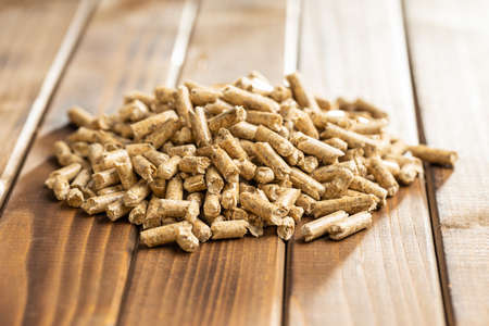 Wooden pellets, biofuel on a wooden table. Ecologic fuel made from biomass. Renewable energy source...