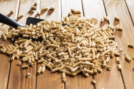 Wooden pellets, biofuel on wooden table. Ecologic fuel made from biomass. Renewable energy source on...