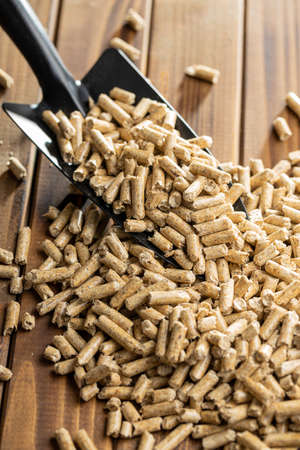 Wooden pellets, biofuel on wooden table. Ecologic fuel made from biomass. Renewable energy source on...
