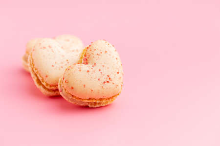 Heart shaped Sweet macarons on a pink background. Top view.の写真素材