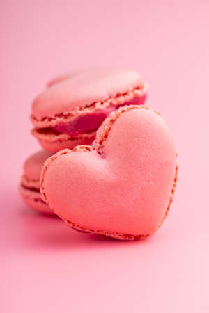 Heart shaped Sweet macarons on a pink background.の写真素材
