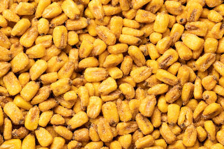 Roasted salted corn snack. Pattern of yellow corn seed. Top view.