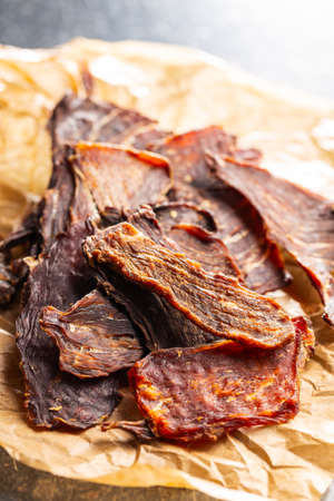 Beef jerky meat. Dried sliced meat on a paper.