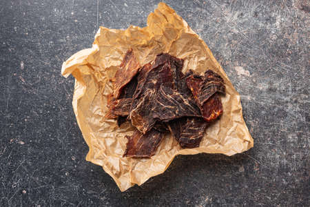 Beef jerky meat. Dried sliced meat on a paper. Top view.の写真素材