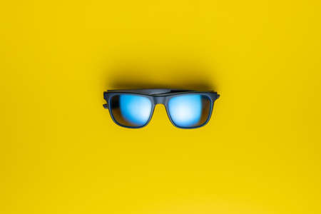 The fashion sunglasses on a yellow background. Top view.