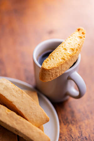 Sweet anicini cookies. Italian biscotti with anise flavor and coffee cup on a wooden table.の写真素材