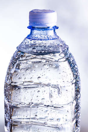 Detail of plastic cold bottle of water with the water drops.