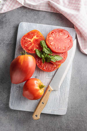 Sliced bull heart tomatoes on a cutting board. Top view.の写真素材
