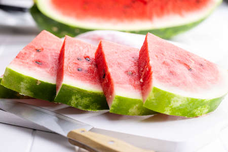 Slices of red watermelon on a cutting board.