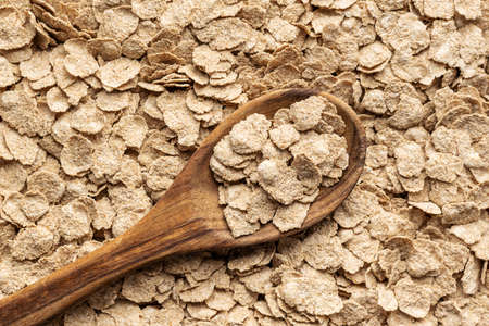 Whole grain cereal flakes. Wholegrain breakfast cereals in a wooden spoon.