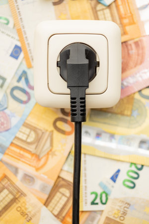 Electric wall socket and euro money. Concept of the increasing electricity prices. Top view.の写真素材
