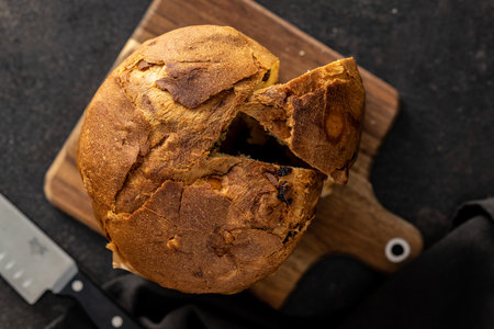 Panettone Christmas Cake. Italian sweet bread on the black kitchen table. Top view.
