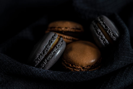 Sweet macaron dessert on the black fabric napkin.の写真素材