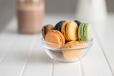 Sweet macaron dessert. Colorful macarons in a bowl on the white table.の写真素材