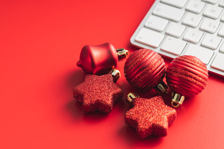 Red christmas decoration. Christmas bulbs and computer keyboard on the red background.の写真素材