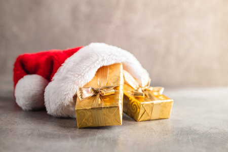 Gold christmas gift in the red Santa hat.の写真素材