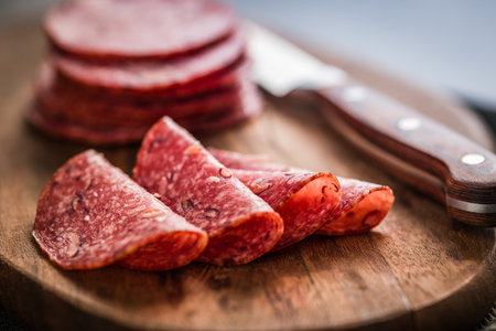 Sliced mexican salami with beans on the cutting board.