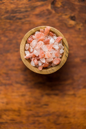 Pink himalayan salt in bowl on the wooden table. Top view.の写真素材