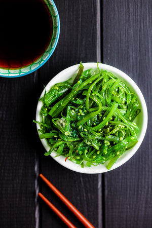 Green seaweed. Japanese wakame salad and soy sauce. Top view.