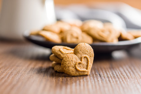 Sweet gingerbread hearts on the wooden table.