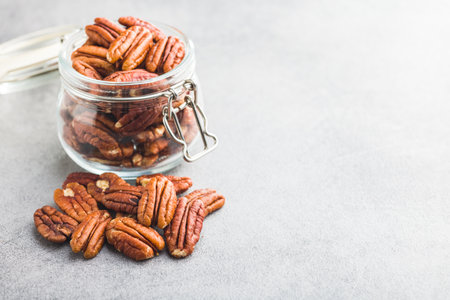 Peeled pecan nuts in a jar on the kitchen table.