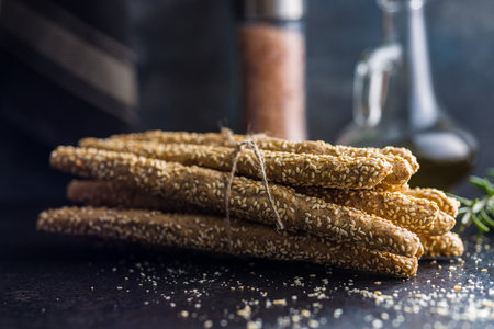 Italian grissini bread sticks with sesame seeds on the kitchen table.の写真素材